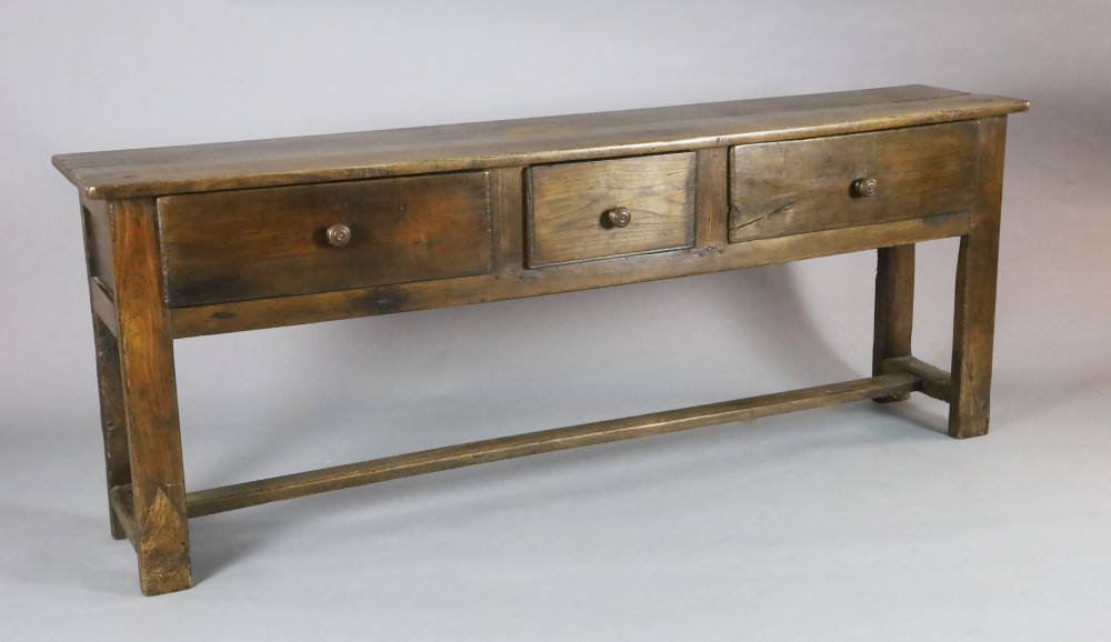 A late 18th century style oak dresser base, fitted three long drawers, on stile feet with H stretcher, W.6ft 7in. D.1ft 4in. H.2ft 6in.